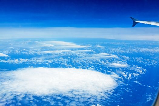 over the clouds, view during a flight over the blue ocean