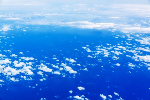 over the clouds, view during a flight over the blue ocean