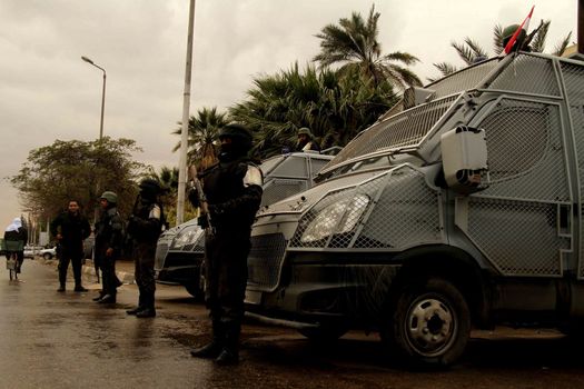 EGYPT, Cairo: Members of the Central Security Force stand in front of armored vehicles in Cairo, on January 25, 2016, on the 5 year anniversary of the 2011 uprisings. Tahrir Square saw a large security presence, after armed clashes broke out the previous two years between police and demonstrators.