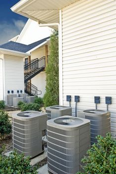 Vertical shot of a group of air conditioning units at an apartment complex.