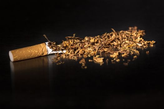 Broken cigarette on black background, reflected, stop smoking