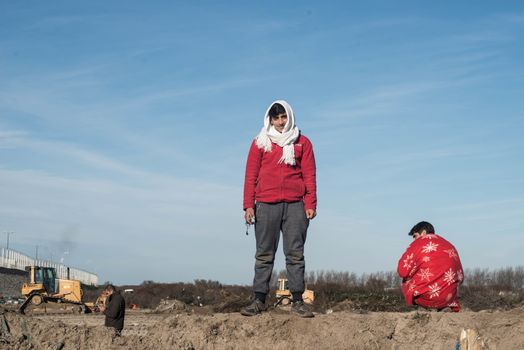 FRANCE, Calais: A migrant stand on January 25, 2016, in the migrant shantytown on the outskirts of Calais known as the Jungle, where thousands are trying to make their way across the English Channel.A prefectoral decree posted on January 19, 2016, gave people 24 hours to leave the premises of a 100 metre wide strip of land in the jungle, where several small food businesses and restaurants had been set up, before its evacuation and destruction.