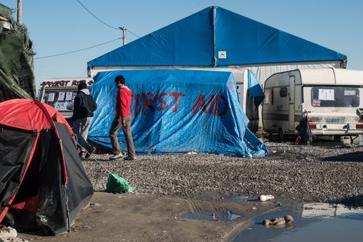 FRANCE, Calais: People walk on January 25, 2016, in the migrant shantytown on the outskirts of Calais known as the Jungle, where thousands are trying to make their way across the English Channel.A prefectoral decree posted on January 19, 2016, gave people 24 hours to leave the premises of a 100 metre wide strip of land in the jungle, where several small food businesses and restaurants had been set up, before its evacuation and destruction.
