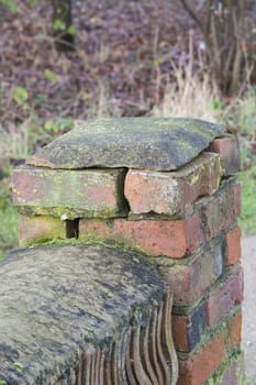 end of a weathered brick wall showing cracks and missing mortar