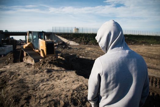 FRANCE, Calais: A migrant watches a bulldozer demolish part of the Jungle in Calais, northern France on January 25, 2016.