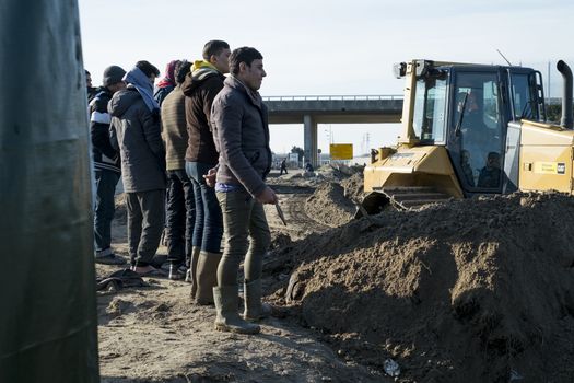 FRANCE, Calais: Migrants watch as bulldozers demolish part of the Jungle in Calais on January 25, 2016.