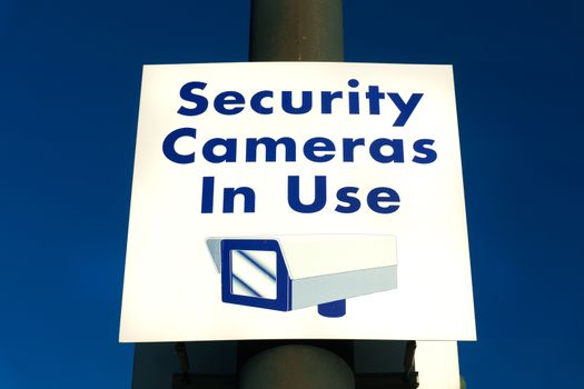 Security cameras in use sign in municipal public area.