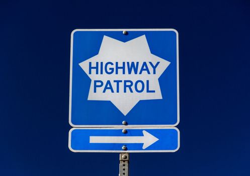 Roadside Highway Patrol sign with arrow pointing right.