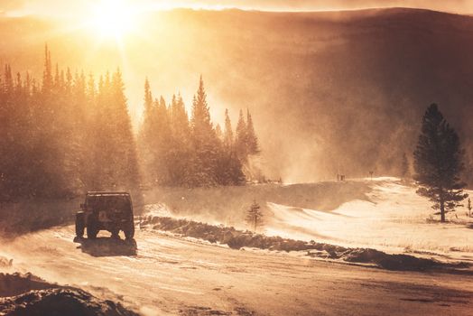 Extreme Winter Road Condition. Colorado Mountain Road and the Winter Storm with High Wind. All Wheels Drive SUV on the Icy Road Covered by Snow.