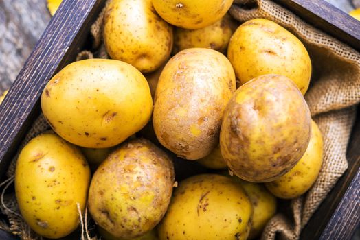 Idaho Golden Potatoes. Raw Potatoes in Small Wooden Crate.