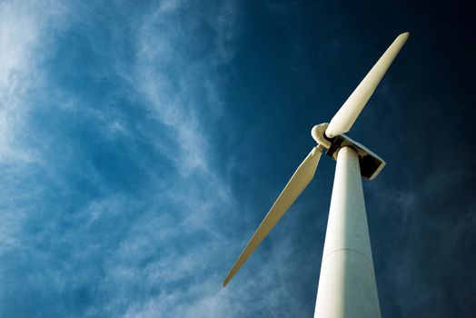 Lonely Wind Turbine and the Dark Cloudy Blue Sky. Wind Energy.