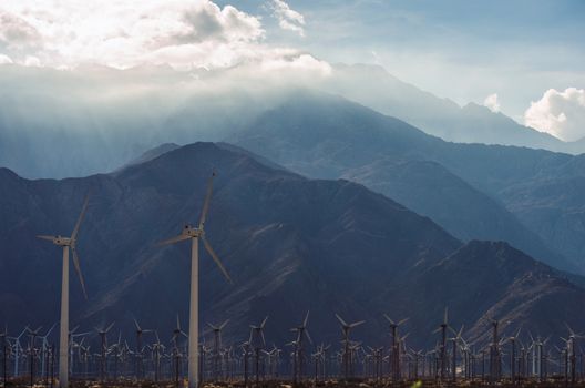 Coachella Valley Wind Turbines Farm and Cloudy Mountains Scenery. California Alternative Energy Source. 