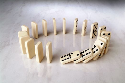 row of dominoes in a circle shape on a neutral background