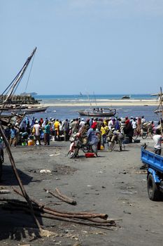 Stone Town, Tanzania - December 30, 2015: Fish market. Streets of the town are always lively. There is alwais a lot of local people and tourists. On the fish market the smell is so strong that you can not stand in there for a long time. Fish market in Stone town, a man in traditional clothing is offering his fishes that are on the table.