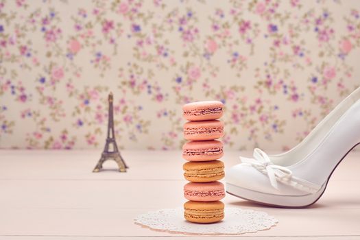 Macarons french dessert. Eiffel Tower, souvenir from Paris,  luxury shoes high heels. Creative wedding set, vanilla wood, floral background. Romantic, still life. Retro vintage 