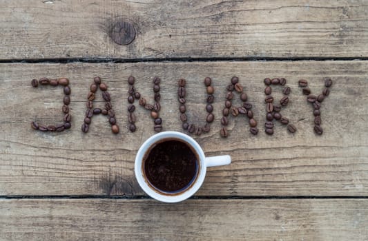 Cup of coffee on wooden background and January coffee beans