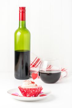 Red velvet cupcake with a glass of red wine for valentines day.