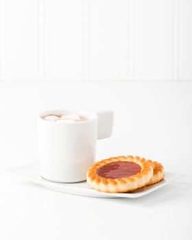 Strawberry jam filled cookies served with hot chocolate.