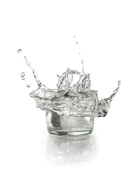 Glass with splashing water on white background. Clipping path is included