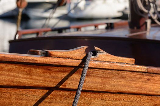 Fragmentary view details of knots and ropes on the yacht moored in the dock. Passing through the anchor