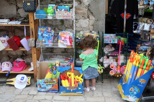 Adorable baby looking toys in shop