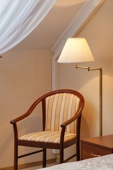 the lamp and chair in the room about a window