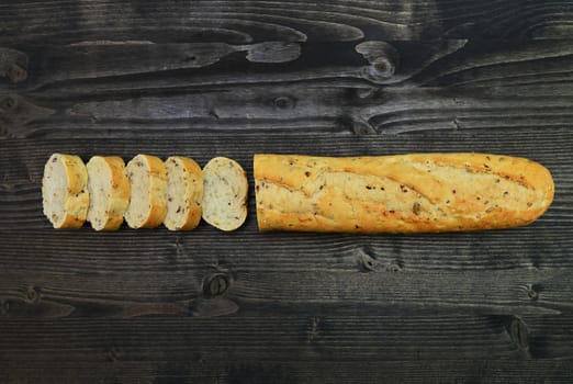 rustic baguette bread over dark wood background