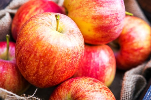 Fresh Red Apples Closeup Photo. Red Organic Apples in the Wooden Crate and Canvas.