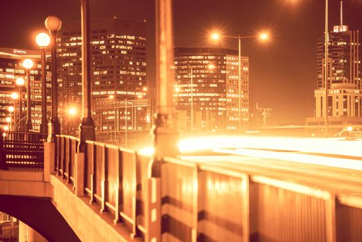 Denver Urban Scenery. Bridge at Night and Part of Denver Skyline. Warm Reddish Color Grading.