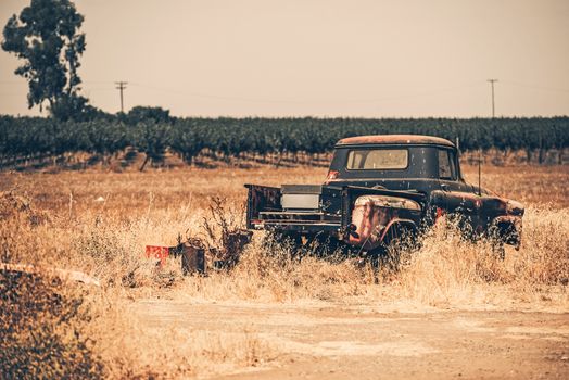Junk Aged Pickup on the Dry California Meadow. History of American Transportation.
