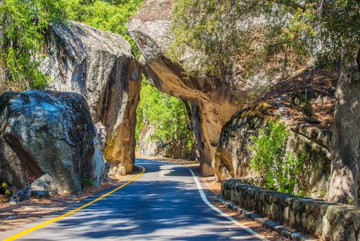 Natural Stone Bridge and the Road Through Sierra Nevada Mountains in California.