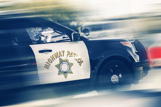 California Highway Police in Motion. SUV Police Cruiser on a Highway.