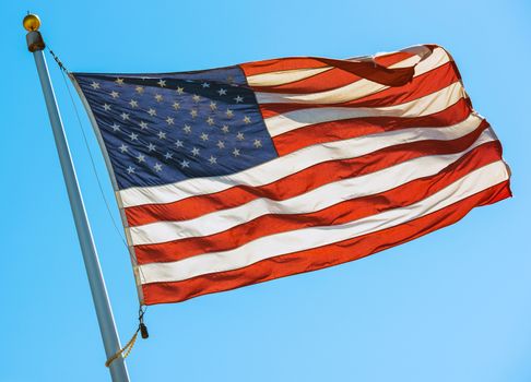 American Flag on a Pole. Waving United States Flag on the Blue Sky.