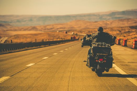 Biker Riding Motorcycle on the Nevada HIghway, USA. Motorbiking Theme.