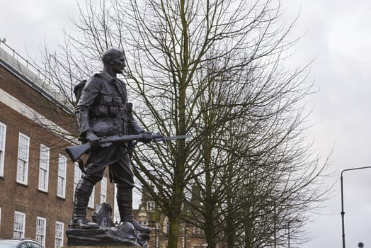 TUNBRIDGE WELLS, UK - JANUARY 26: Side shot of bronze War memorial depicting soldier holding rifle. January 26, 2016 in Tunbridge Wells.
