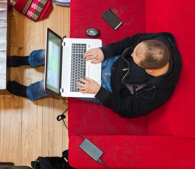 High angle view of a man using his laptop in bright living room