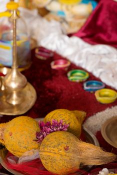 Traditional Indian Hindu religious praying items in ear piercing ceremony for children. Focus on the coconuts.