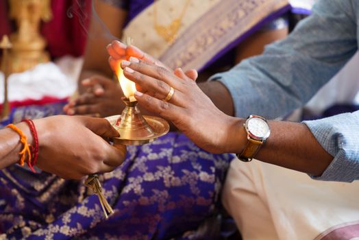 People received prayers from priest. Traditional Indian Hindus praying ceremony. Focus on the oil lamp. India special rituals events.