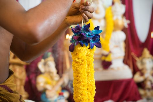 Tie up flower garland. Traditional Indian Hindus ear piercing ceremony. India special rituals.