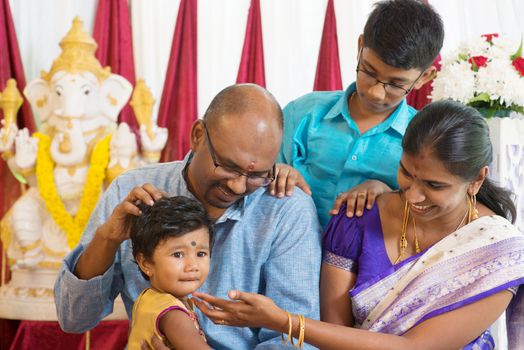 Indian parents and children in a blessing ceremony inside Hindu temple. Traditional India family portrait.