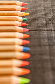 Group of crayons and they are on wooden background, the picture is blurred