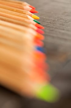 Group of crayons and they are on wooden background, the picture is blurred
