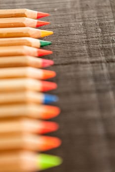 Group of crayons and they are on wooden background, the picture is blurred