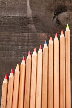 Group of crayons and they are on wooden background, the picture is blurred