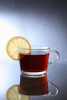 Cup of black tea with lemon on nice dark background