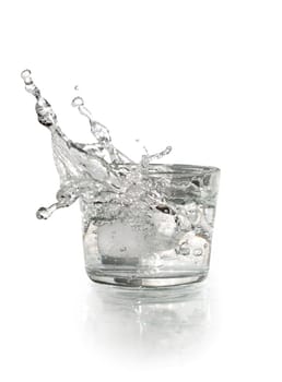 Glass with splashing water on white background. Clipping path is included