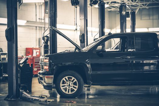 Large Auto Service Warehouse Interior and Pickup Truck Under Maintenance. 