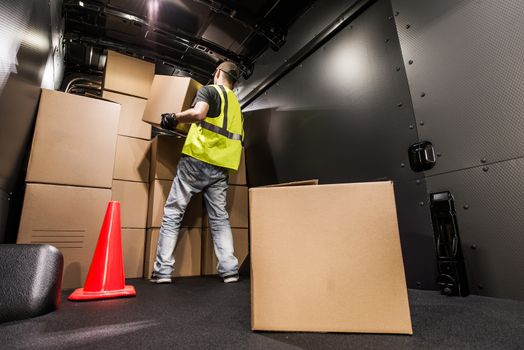 Cargo Van Loading by Worker. Man Carrying Boxes In the Cargo Van For Customer Delivery. Shipment Preparation and Processing.