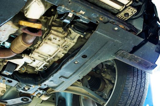 Rusty Car Undercarriage Closeup Photo. Car in Auto Service. Lifted Broken Car.
