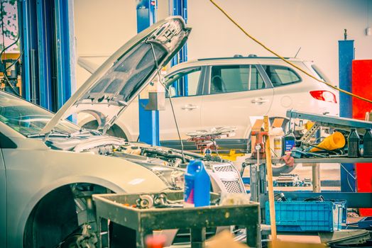 Cars Repairing in Auto Service. Broken Cars on Lifts.